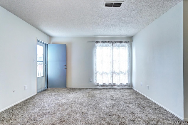 empty room featuring visible vents, carpet floors, and a wealth of natural light