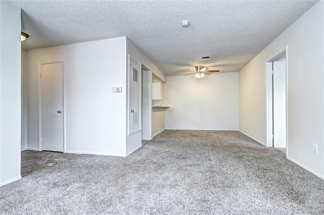 interior space with a textured ceiling, ceiling fan, and baseboards