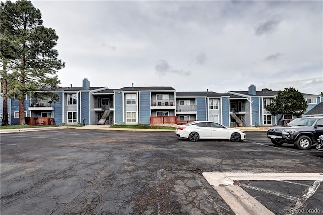 view of front of property featuring a residential view, uncovered parking, and a chimney