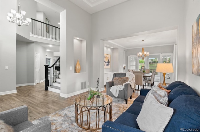 3041 Starling Ct, Castle Rock, CO 80109 - living room featuring a chandelier, stairs, wood finished floors, baseboards, and a towering ceiling