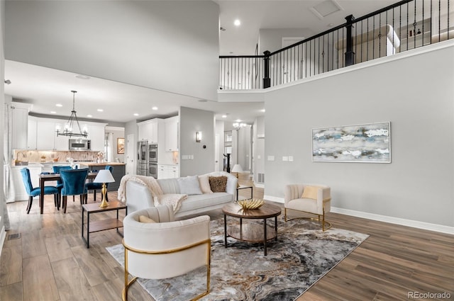 3041 Starling Ct, Castle Rock, CO 80109 - living area with light wood-type flooring, a chandelier, recessed lighting, baseboards, and a towering ceiling