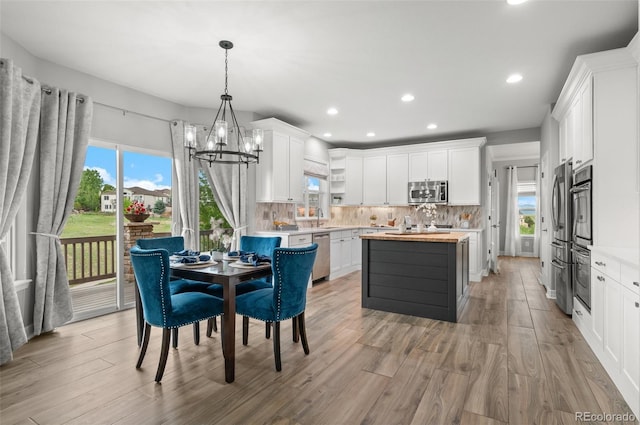 3041 Starling Ct, Castle Rock, CO 80109 - kitchen with stainless steel appliances, a sink, a chandelier, a kitchen island, and decorative backsplash