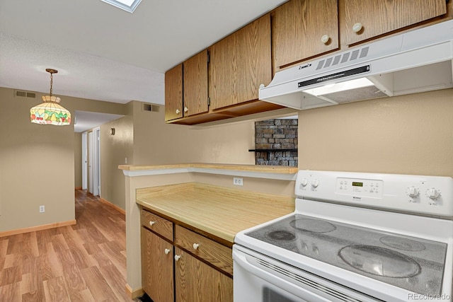 kitchen with electric range, light hardwood / wood-style floors, and hanging light fixtures