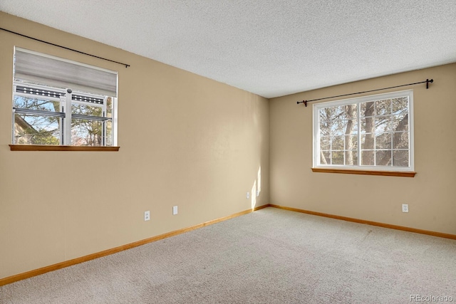 carpeted spare room with a textured ceiling