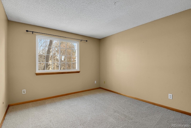 carpeted empty room featuring a textured ceiling