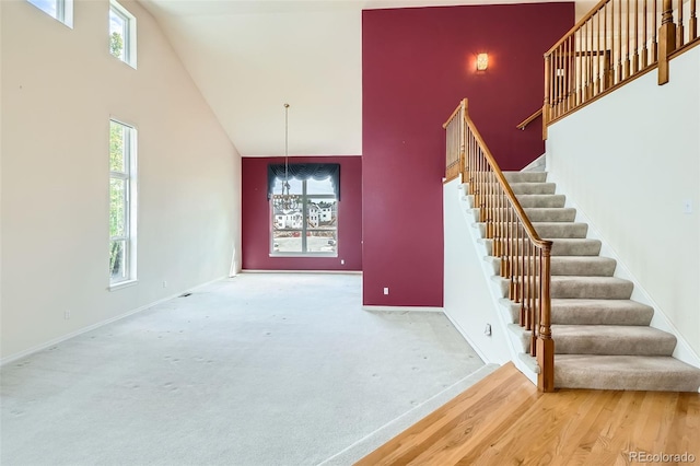 2561 Cactus Bluff Pl, Highlands Ranch, CO 80129 - staircase featuring high vaulted ceiling, plenty of natural light, and wood finished floors