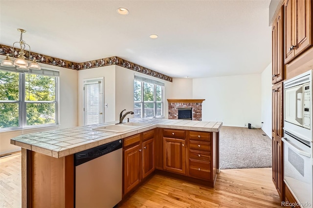 2561 Cactus Bluff Pl, Highlands Ranch, CO 80129 - kitchen with dishwasher, oven, open floor plan, brown cabinets, and tile countertops