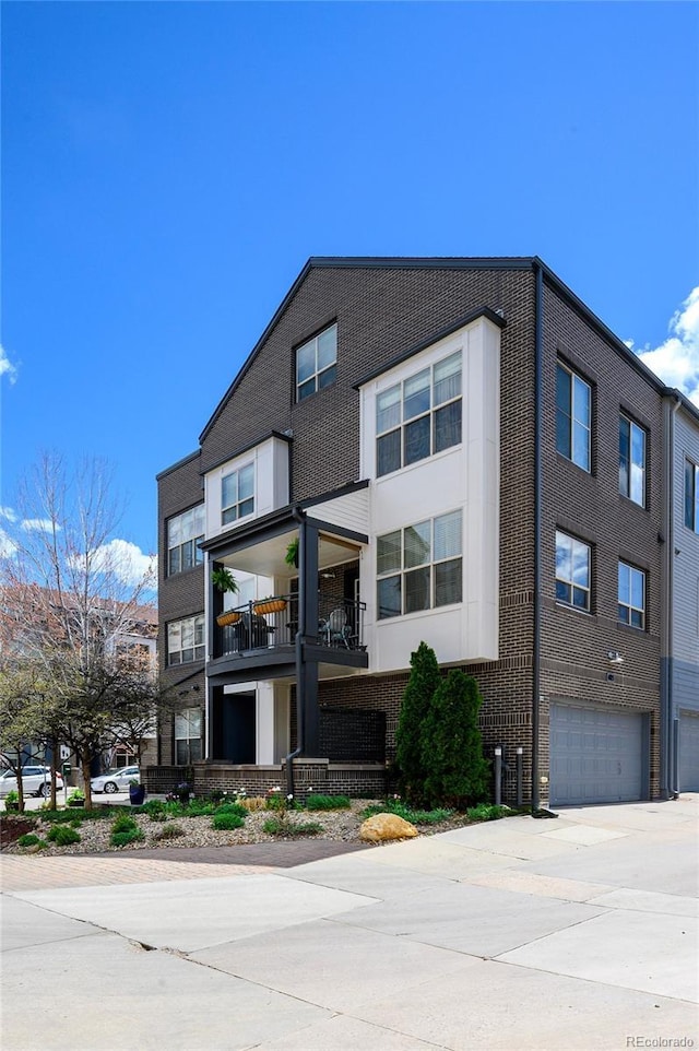 view of front of house featuring a garage, brick siding, and concrete driveway