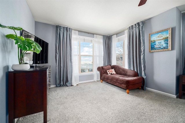 sitting room with carpet, baseboards, and ceiling fan