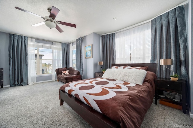 carpeted bedroom featuring a ceiling fan and a textured ceiling