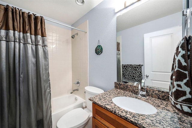 bathroom with toilet, a textured wall, vanity, and shower / bath combo with shower curtain