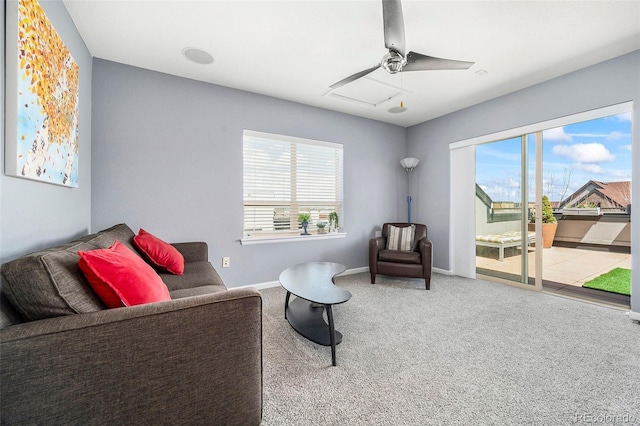 sitting room featuring ceiling fan, a wealth of natural light, carpet floors, and baseboards