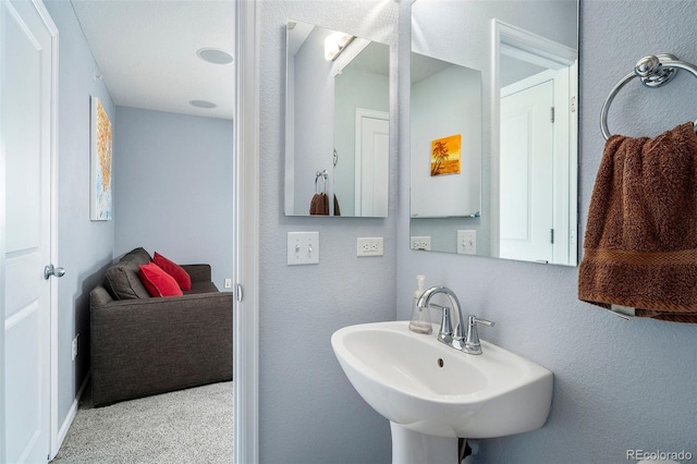 bathroom with a textured wall and a sink