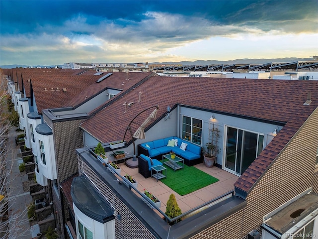 back of house featuring an outdoor living space and roof with shingles