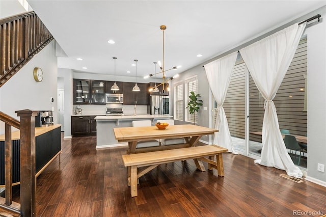 dining room featuring sink, dark hardwood / wood-style flooring, and an inviting chandelier