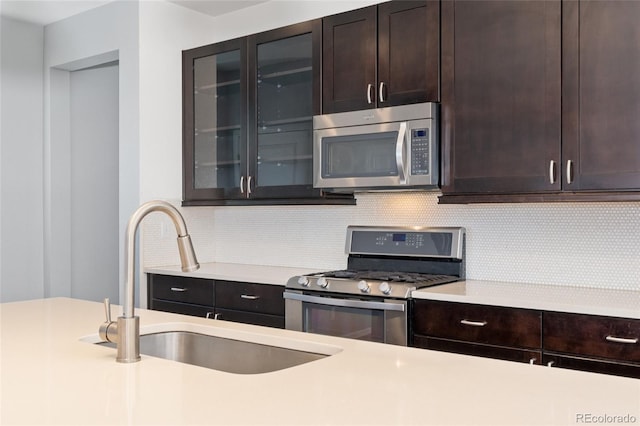 kitchen with decorative backsplash, sink, dark brown cabinetry, and stainless steel appliances