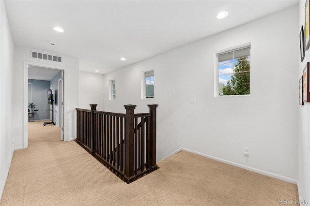 hall with light colored carpet and plenty of natural light