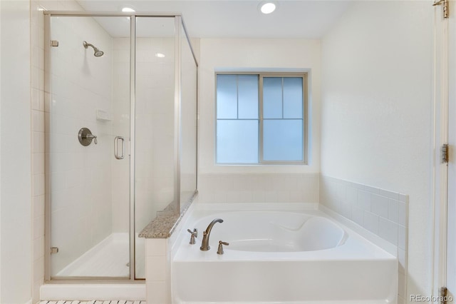 bathroom featuring shower with separate bathtub