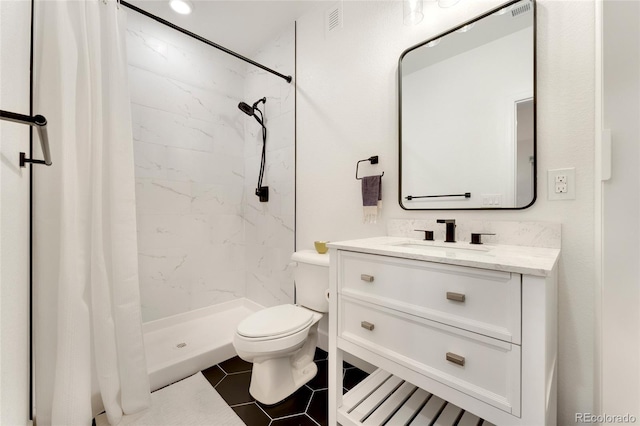 bathroom with walk in shower, vanity, tile patterned flooring, and toilet