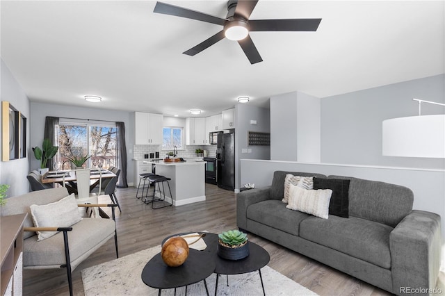 living area featuring light wood finished floors and ceiling fan