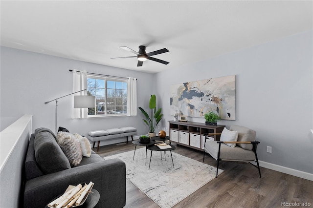 living area with a ceiling fan, baseboards, and wood finished floors