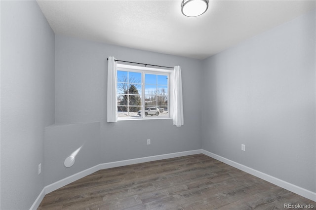 empty room featuring baseboards and wood finished floors