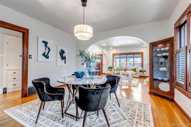 285 S Williams St, Denver, CO 80209 - dining room featuring arched walkways, light wood finished floors, baseboards, and visible vents