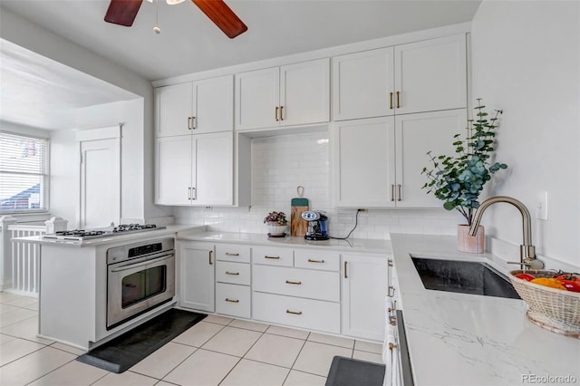 285 S Williams St, Denver, CO 80209 - kitchen featuring oven, a sink, a peninsula, white cabinetry, and gas cooktop