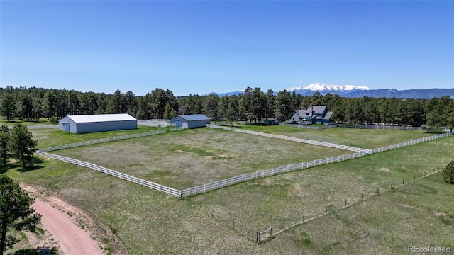 view of yard featuring an outbuilding, a mountain view, a rural view, and a garage