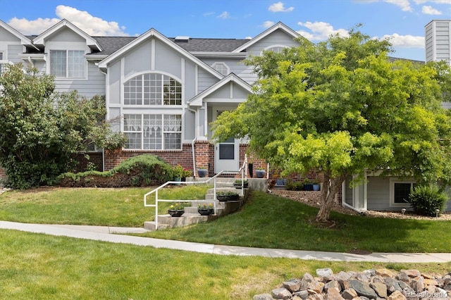 18489 E Columbia Cir, Aurora, CO 80013 - view of front of property featuring a front yard, a shingled roof, and brick siding