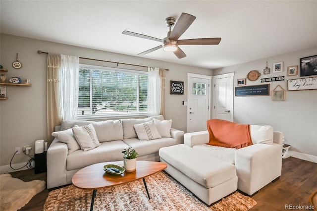 living room featuring dark wood-style flooring, a ceiling fan, and baseboards