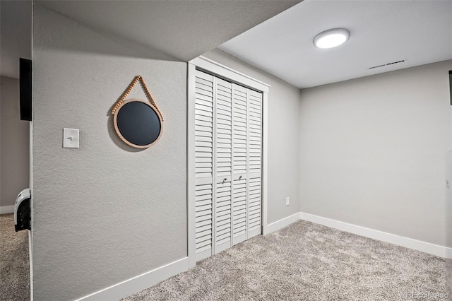 unfurnished bedroom with a closet, carpet flooring, visible vents, and baseboards