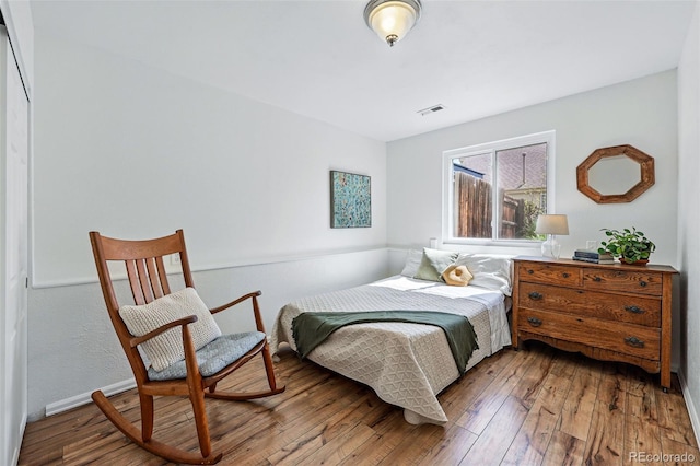 bedroom featuring hardwood / wood-style flooring and baseboards