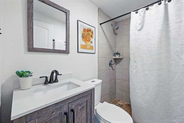 full bath with toilet, a tile shower, and vanity