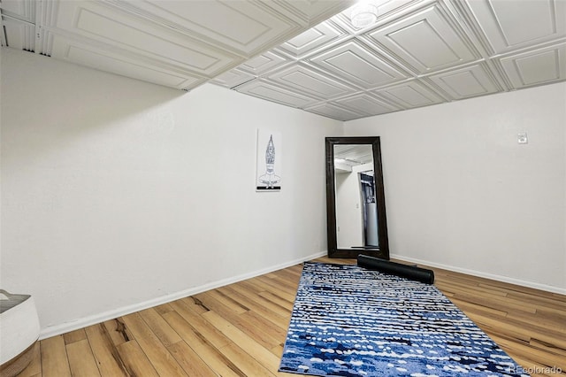 unfurnished room with light wood-style floors, baseboards, and an ornate ceiling