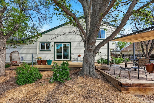 rear view of house featuring a deck and outdoor dining space