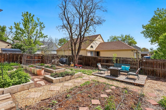 fenced backyard with a garden and an outdoor fire pit