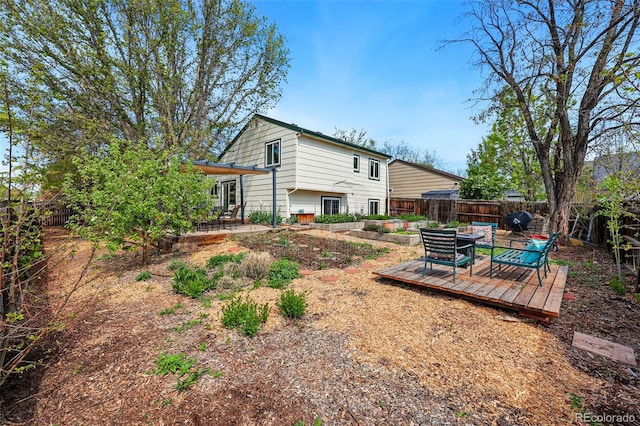 rear view of property featuring a deck and a fenced backyard