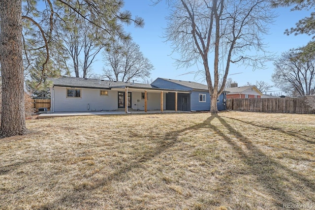 back of house featuring a patio, fence, and a lawn