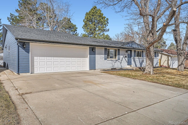 single story home featuring a garage, driveway, and a shingled roof