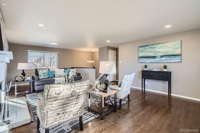 living area with recessed lighting, a fireplace with flush hearth, wood finished floors, baseboards, and an inviting chandelier