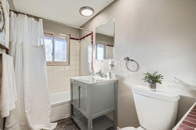 full bath with toilet, a textured wall, vanity, and shower / tub combo with curtain