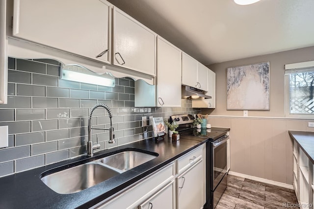 kitchen with white cabinets, dark wood-style floors, under cabinet range hood, stainless steel range with electric stovetop, and a sink