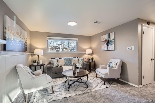 living area featuring baseboards, visible vents, and carpet flooring