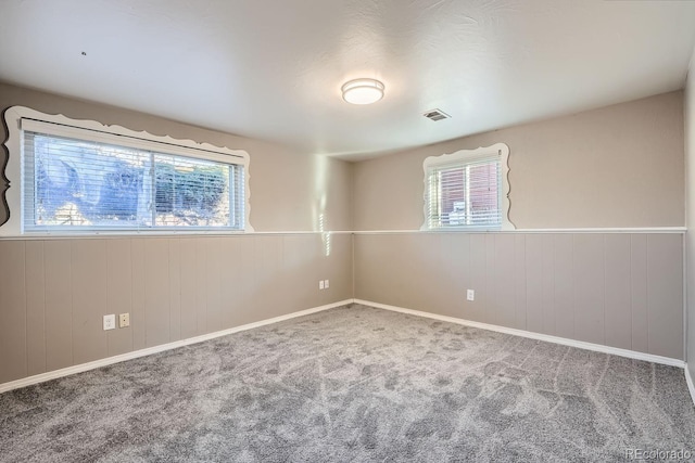 carpeted spare room with a wealth of natural light and visible vents