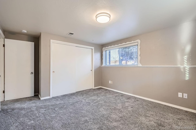 unfurnished bedroom with carpet, a closet, and visible vents