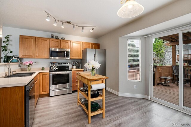 8129 Locust Dr, Littleton, CO 80125 - kitchen featuring stainless steel appliances, a sink, light wood finished floors, and baseboards