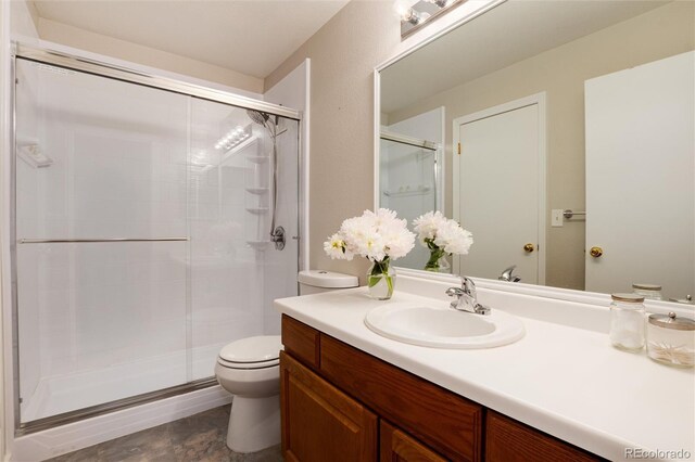 8129 Locust Dr, Littleton, CO 80125 - bathroom featuring vanity, a stall shower, and toilet