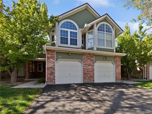 2418 W 82nd Pl Unit D, Westminster, CO 80031 - view of front of home with an attached garage, brick siding, and driveway