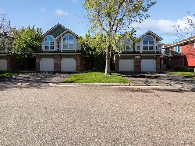 2418 W 82nd Pl Unit D, Westminster, CO 80031 - view of front facade with brick siding, aphalt driveway, and an attached garage